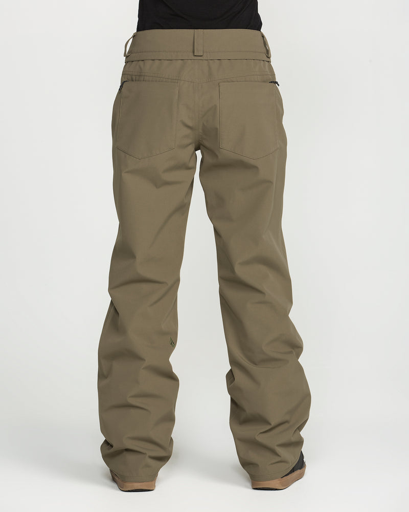 A person is shown from the back, standing against a plain white background, wearing Volcom Women’s Stoned Pants in olive green with a loose fit.