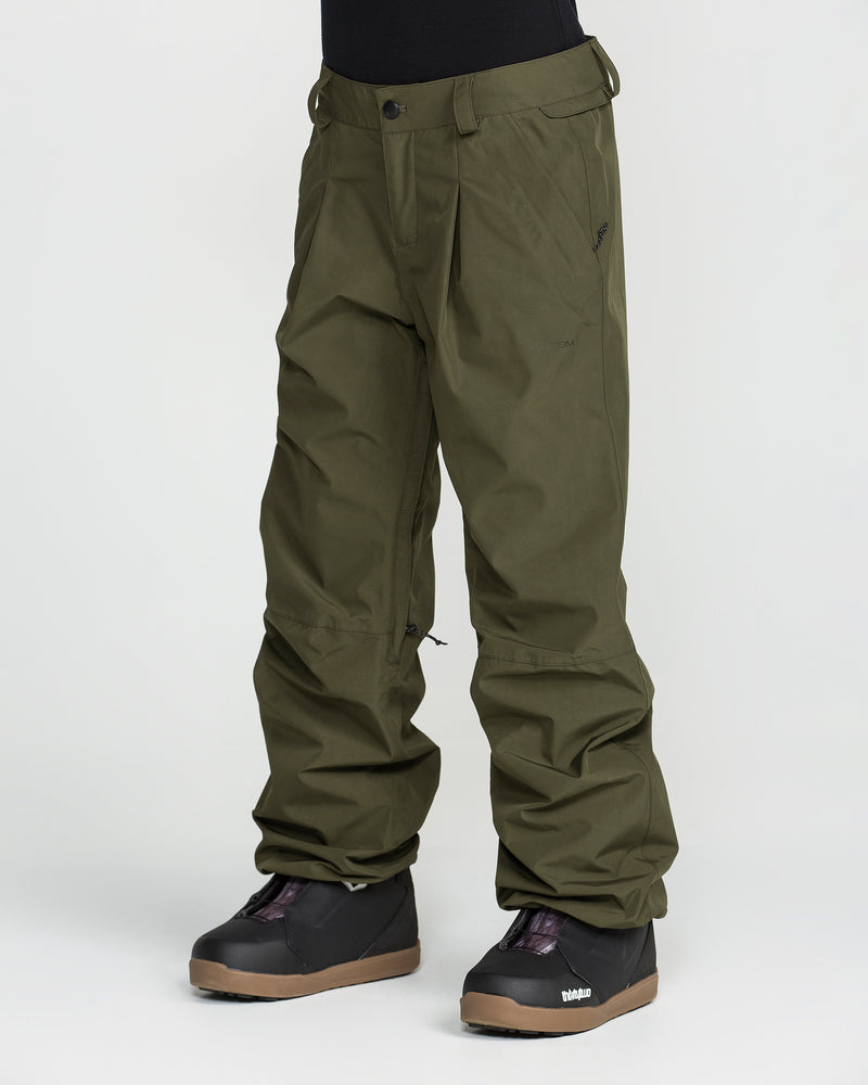 A person wearing Volcom Unisex Yourfav Baggy Gore Pants in olive green, featuring an adjustable waist, paired with black snow boots. The lower half of the body is shown against a plain white background.