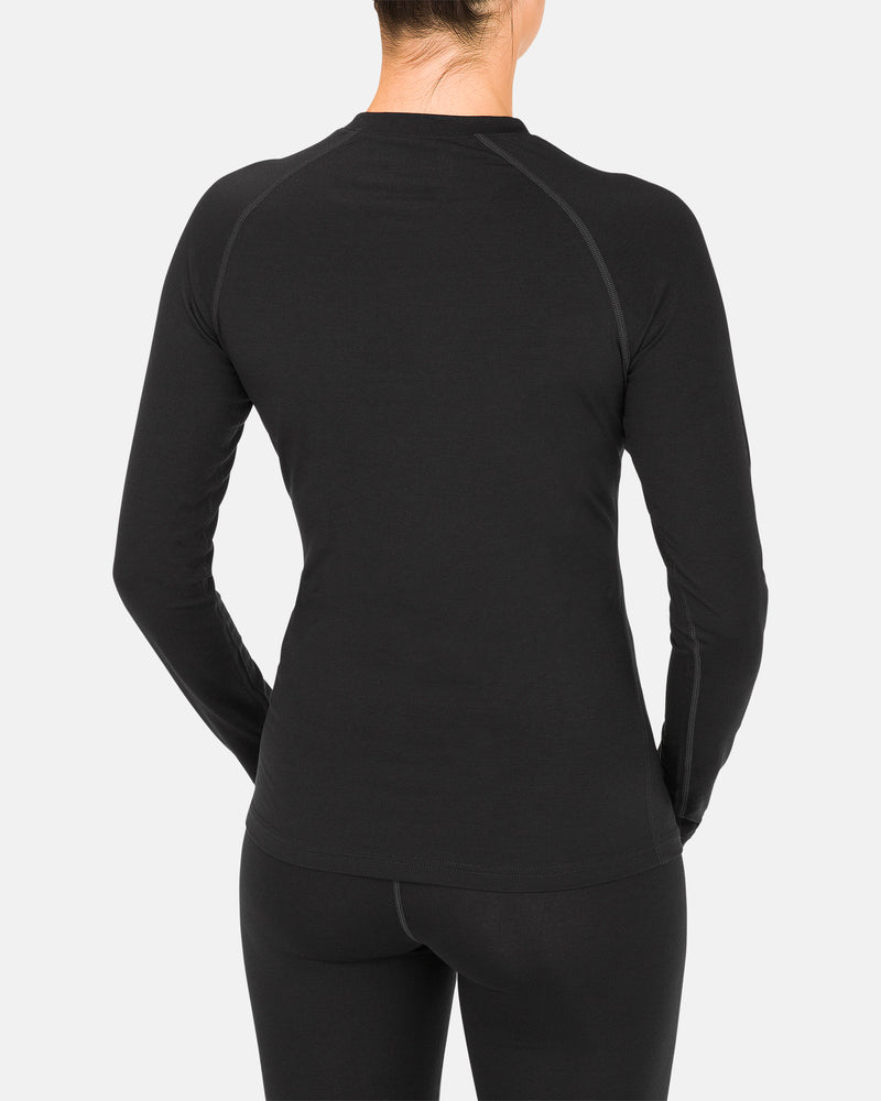 A person is shown from the back against a plain white background, wearing the Volcom Women’s W Merino Blend Crew in black with fitted long sleeves and matching black leggings.