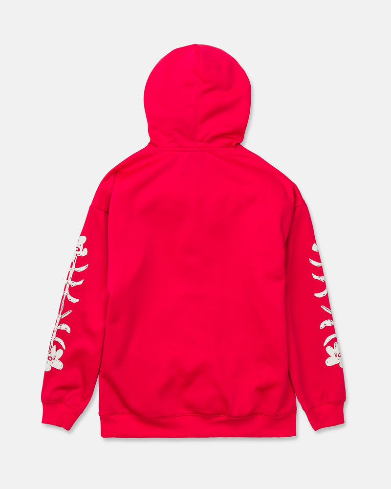 A vibrant red Volcom Women’s Essential Hydro Hoodie is shown from the back, with striking white skeleton bone graphics running down each sleeve. The hood is up, showcasing the hydrophobic fleece design against a plain backdrop.