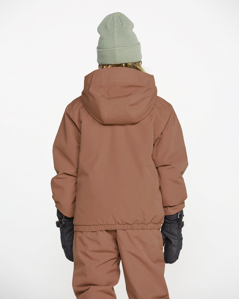 A child wearing the Volcom Kids’ Youth Chaos Insulated Jacket, paired with brown pants, black gloves, and a light green knit beanie, stands facing away from the camera against a plain white background—ready for any forecast with weather defense technology and cozy recycled insulation.