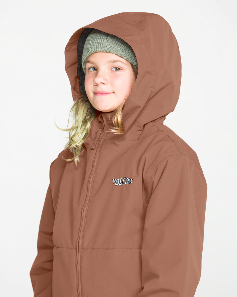 A young person with long blonde hair wears the Volcom Kids’ Youth Chaos Insulated Jacket in brown, which features weather defense technology and recycled insulation. Paired with a green knit beanie, they look slightly to the side and smile against a plain white background.