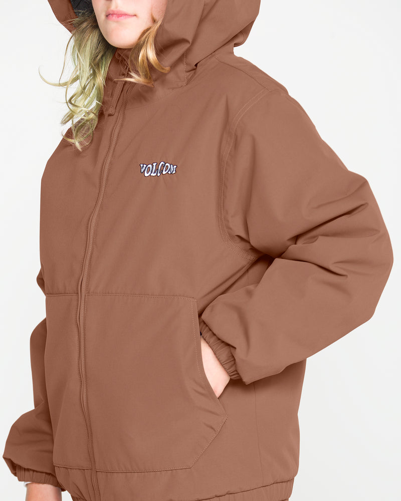 A person with blond hair wears the Volcom Kids’ Youth Chaos Insulated Jacket, a brown hooded design featuring recycled insulation and weather defense technology with “VOLCOM” embroidered on the chest, standing against a plain light background.