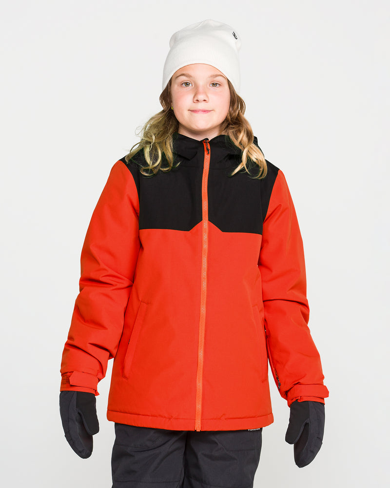 A child stands facing forward against a plain white background wearing the Volcom Kids’ Youth Stone.91 Insulated Jacket in red and black, featuring recycled insulation, along with a white beanie and gloves.