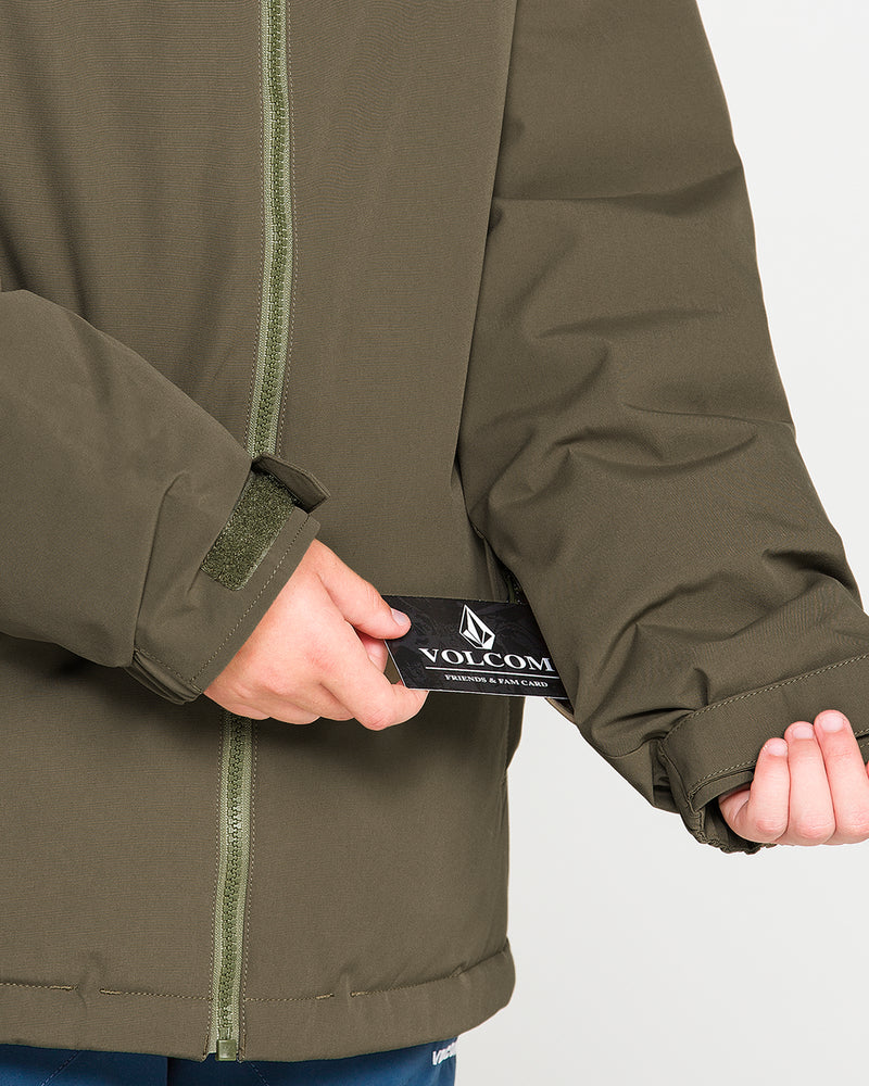 A person wearing the Volcom Kids’ Youth Stone.91 Insulated Jacket in olive green adjusts the Velcro cuff with one hand while holding a black Volcom tag with the other. The jacket, made with recycled insulation for added warmth, is displayed from torso to hands against a neutral background.