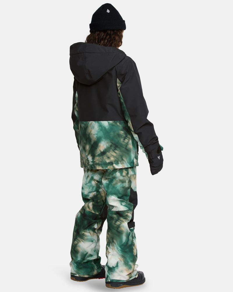 A person stands facing away, wearing a black beanie, a black and green tie-dye hooded winter jacket, and the Kids' Barkley Insulated Bib Overall in matching green tie-dye with gloves. Black winter boots complete the outfit.
