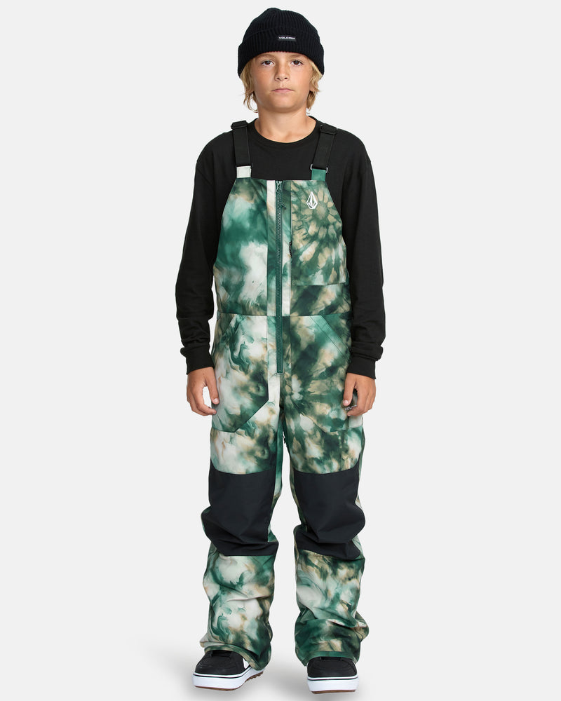 A child wears the Kids' Barkley Insulated Bib Overall in green tie-dye, paired with a black beanie and long-sleeve shirt, standing facing forward against a plain white background.