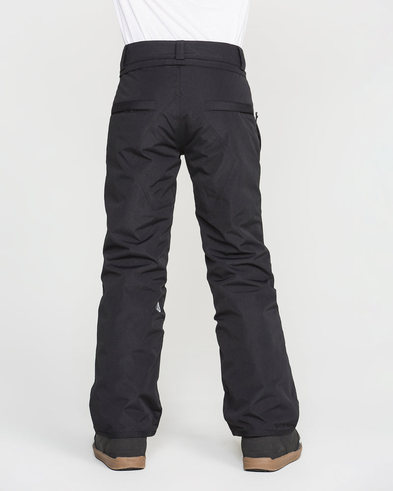A person is shown from the back wearing Volcom Kids’ Youth Freakin Chino Insulated Pants in black and brown boots, standing against a plain white background. These waterproof, breathable pants offer an adjustable waist for comfort and a secure fit.