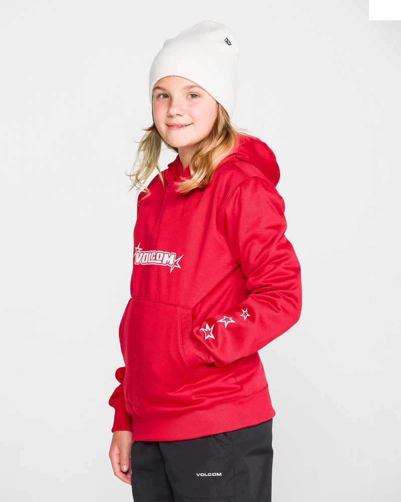 A young person in a red Volcom Kids’ Youth Hydro Fleece Hoodie, featuring star designs on the sleeve and a convenient handwarmer pocket, pairs it with black pants and a white beanie while standing against a plain white background and smiling slightly at the camera. The hoodie is made from hydrophobic fleece for extra comfort.