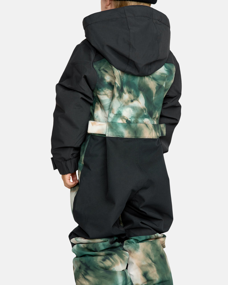 A child is seen from the back wearing the Kids' Little Flurry One Piece, a black and green tie-dye snowsuit with a hood, set against a plain light background.