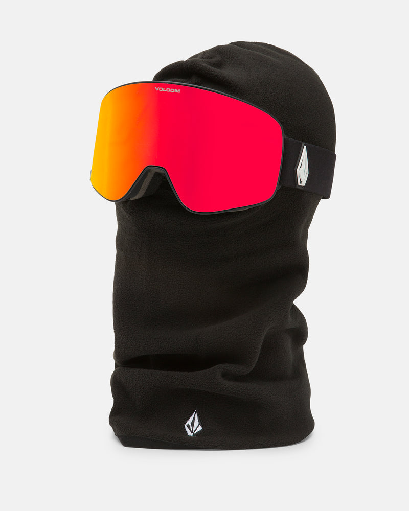 The Volcom Men’s Powclava, a black polyester fleece balaclava, is shown on a mannequin head and paired with red-orange reflective ski goggles that display the Volcom logo on the strap.