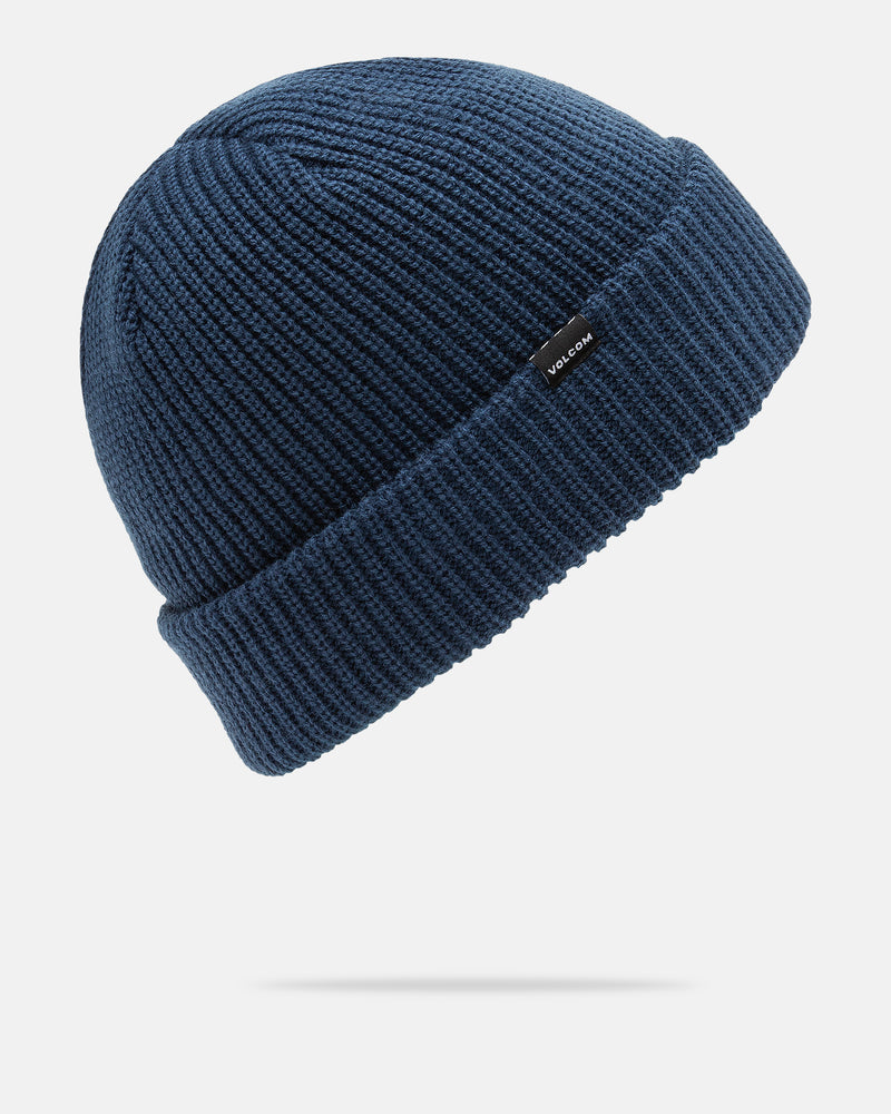 The Men’s Sweep Beanie by Volcom is a blue ribbed knit beanie in a standard fit, featuring a folded cuff and a small black tag with the Volcom brand name. Shown on a white background with a subtle shadow underneath, this cozy acrylic beanie delivers both warmth and style to your outfit.