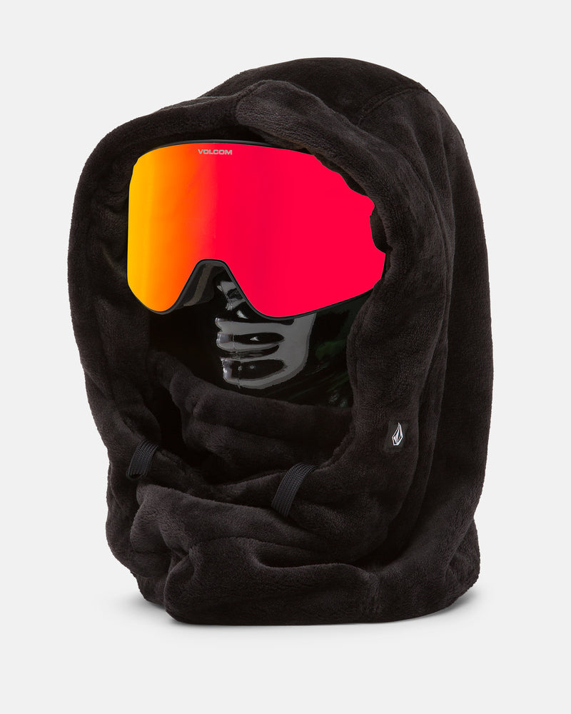 A black mannequin head is shown wearing the Volcom Women’s Dang Hood, a fuzzy black fleece hood that doubles as a neck warmer and features a small Volcom logo on the side. Paired with large red-orange ski goggles, this cozy accessory is perfect for cold weather and offers full coverage for most of the head.