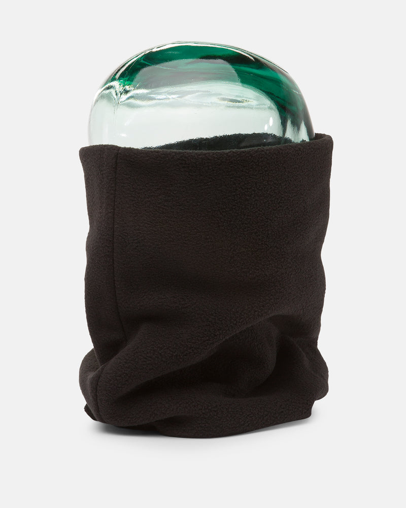 A clear glass head model is wrapped in the Women’s V.Scout Neckband by Volcom, a black polyester fleece neck gaiter, and displayed against a plain white background to showcase both warmth and comfort.