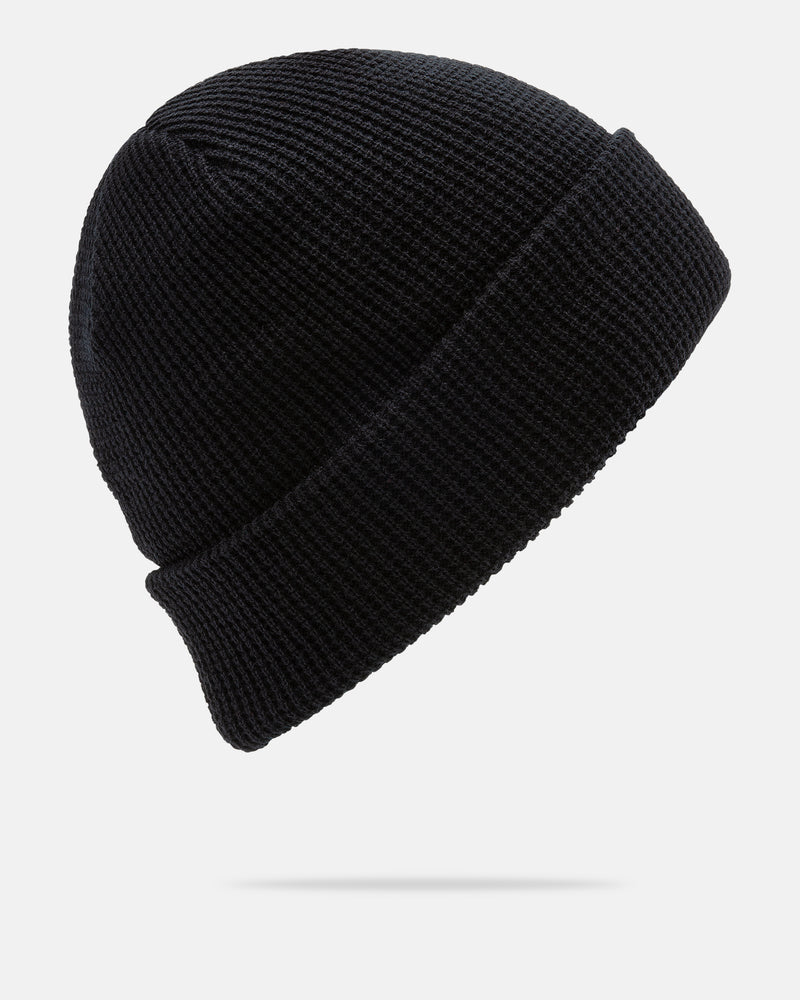 The Volcom Women’s Power Beanie is a black knit hat with a folded brim, displayed against a plain white background and casting a subtle shadow beneath. This stylish beanie provides warmth and versatile flair for any cold-weather outfit.