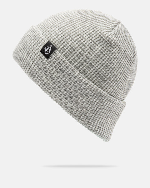 A light gray Volcom Women’s Power Beanie featuring a waffle-knit texture, folded brim, and a small black and white rectangular logo patch on the front, designed for on-mountain sessions and shown against a white background.