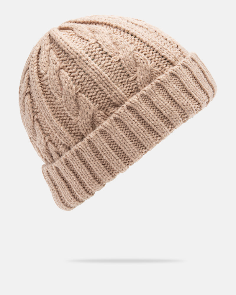 A Women’s Stone Knit Beanie by Volcom, featuring a soft beige cable knit design and a thick folded brim, is displayed against a plain white background—an effortlessly stylish knit beanie perfect for cozy, everyday wear.
