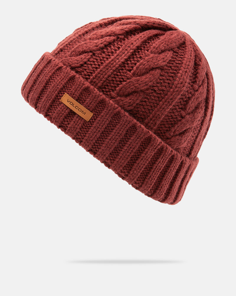 The Women’s Stone Knit Beanie by Volcom is a red, cable-knit beanie for women featuring a folded brim and a small brown Volcom label on the front, shown against a plain white background.