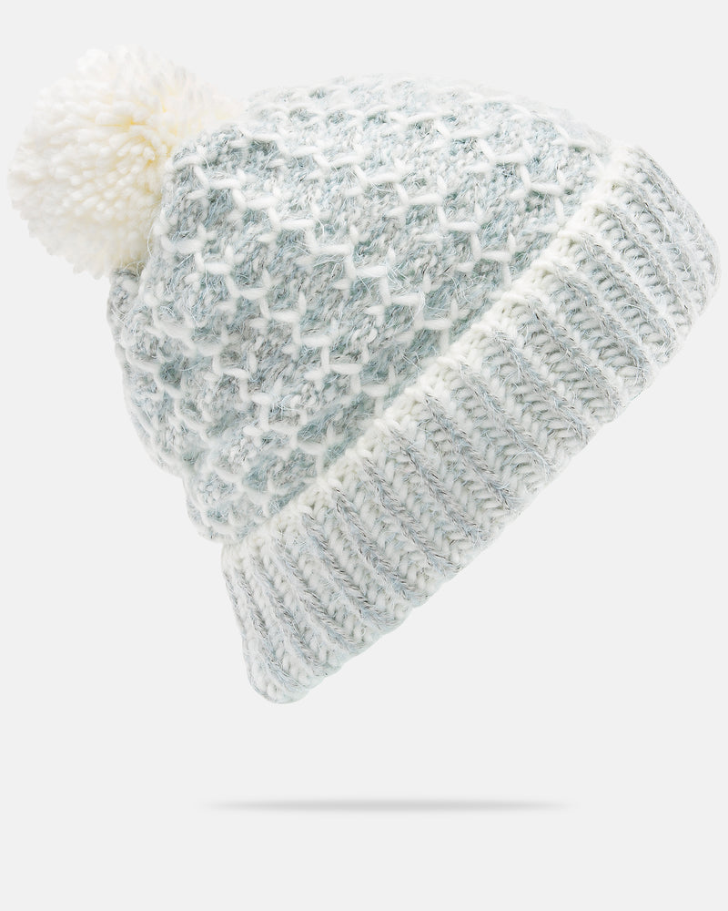 Introducing the Volcom Women’s Frosty Top Beanie—a light gray and white knitted winter hat that features a textured pattern, ribbed cuff, and a large, fluffy faux fur pom on top—perfect for those who value both warmth and style.