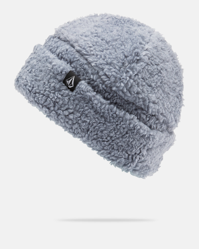 The Volcom Women’s Fuzzed Up Beanie is a light gray, fuzzy sherpa beanie with a classic fit, featuring a black and white Volcom logo patch on the cuff and cozy fleece lining for extra warmth, shown against a plain white background.