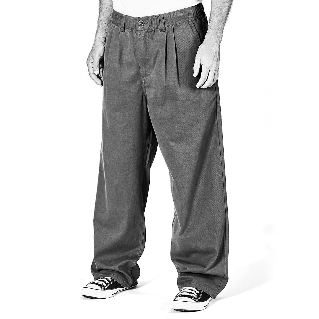 Black and white image of person wearing baggy jeans and sneakers on a white background
