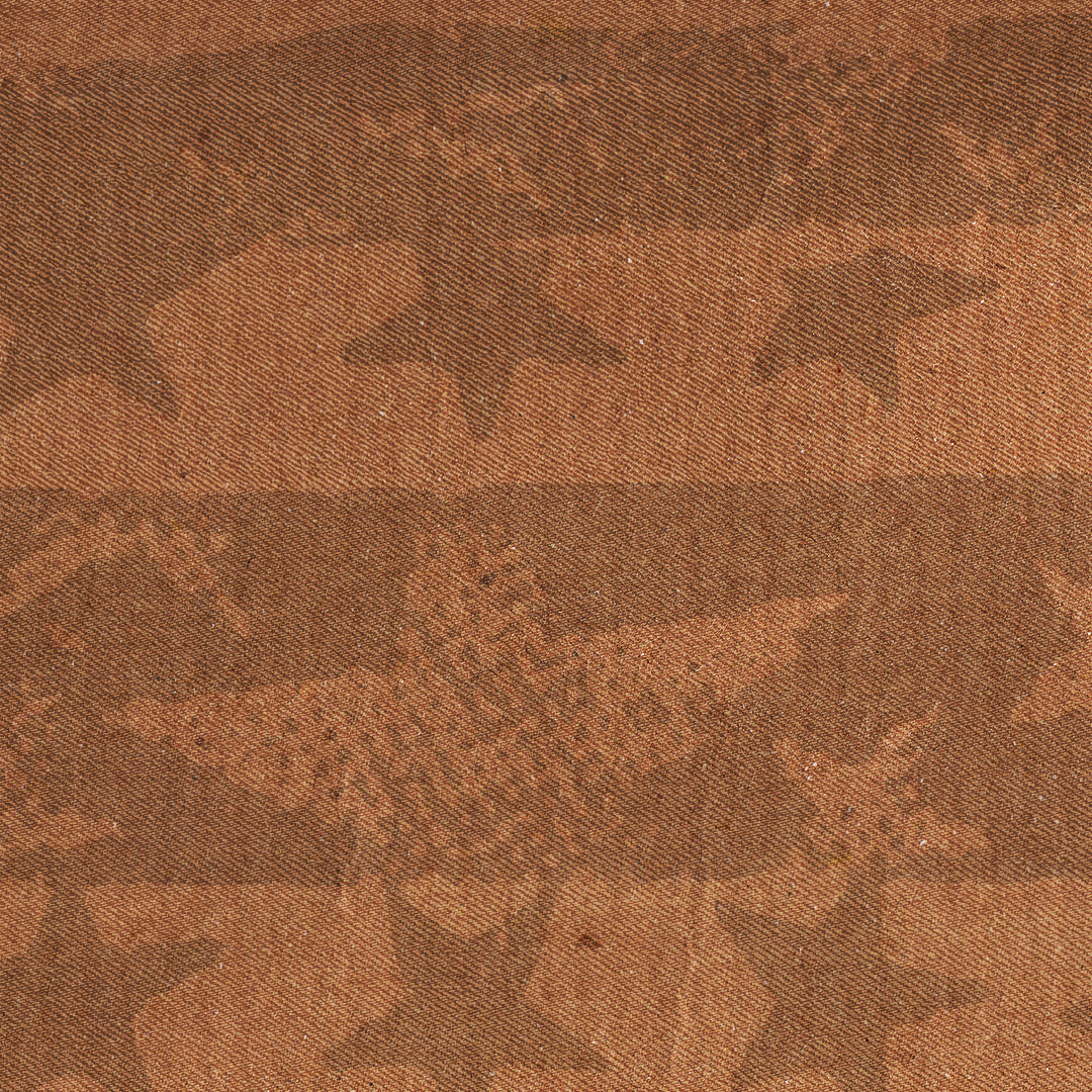 A close-up of a brown woven textile with a subtle repeating pattern of stars and stripes.