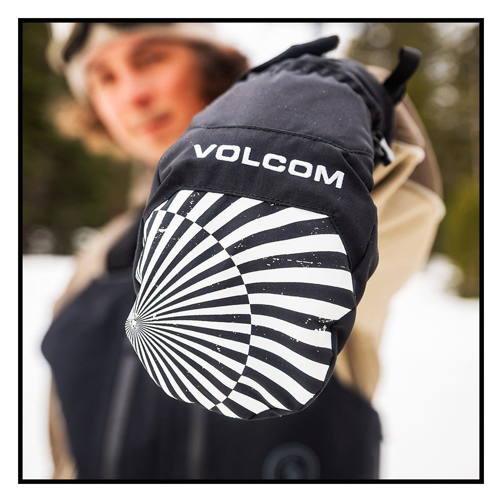 Person holding out hand showing Black Volcom glove with a black and white pattern on a blurred background. 