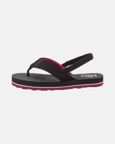 The Volcom Kids' Victor 2 Little Youth sandal is black with a red inner lining and sole, thong-style front strap, and back strap. Shown from the side on white, it features water-friendly materials and recliner comfort foam for support.