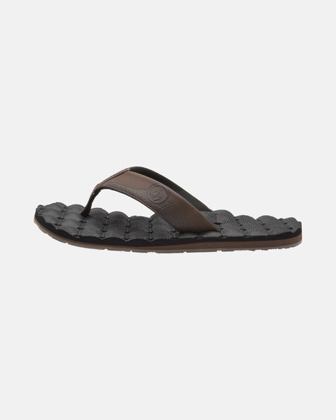 A single Volcom Men's Recliner sandal in brown and black, featuring an extra-grippy textured sole and a woven-style footbed, shown from the side on a plain white background.