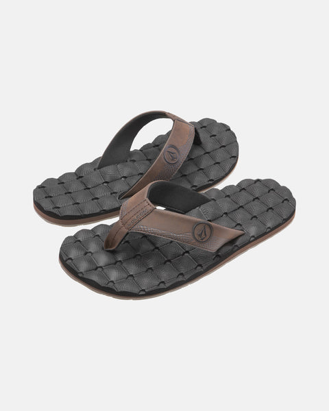 A pair of Volcom Men's Recliner black flip-flop sandals with brown straps and woven textured, extra-grippy soles is displayed on a plain light background.