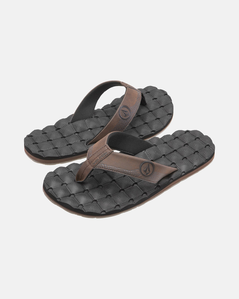 A pair of Volcom Men's Recliner black flip-flop sandals with brown straps and woven textured, extra-grippy soles is displayed on a plain light background.