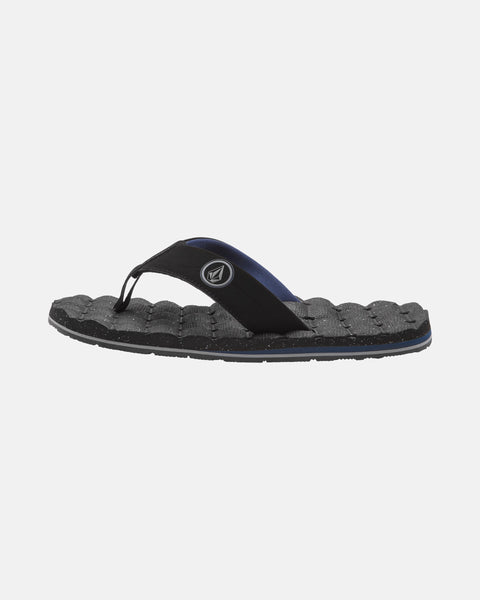 The Volcom Men's Recliner is a black flip-flop featuring textured, cushy, grippy soles, black fabric thong straps, and a circular logo on the side strap, shown against a plain white background.