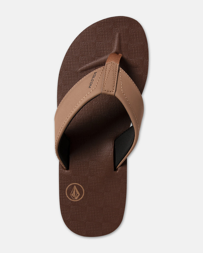 The Volcom Men's Victor is a brown flip-flop sandal with tan straps, a textured footbed, and the Volcom logo near the heel, shown from above on a light background.