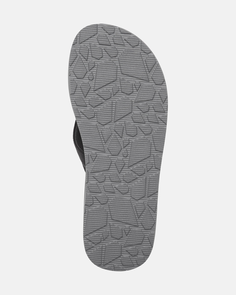 The image features the sole of the Men’s Victor Sandals by Volcom in gray, displaying a textured geometric tread pattern. Set against a white background, it highlights the water-friendly design of these sandals.