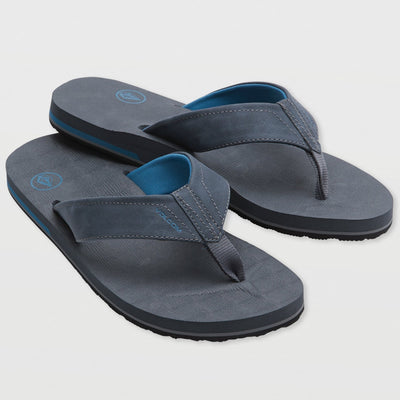 Pair of gray sandals with blue soles on a light gray background