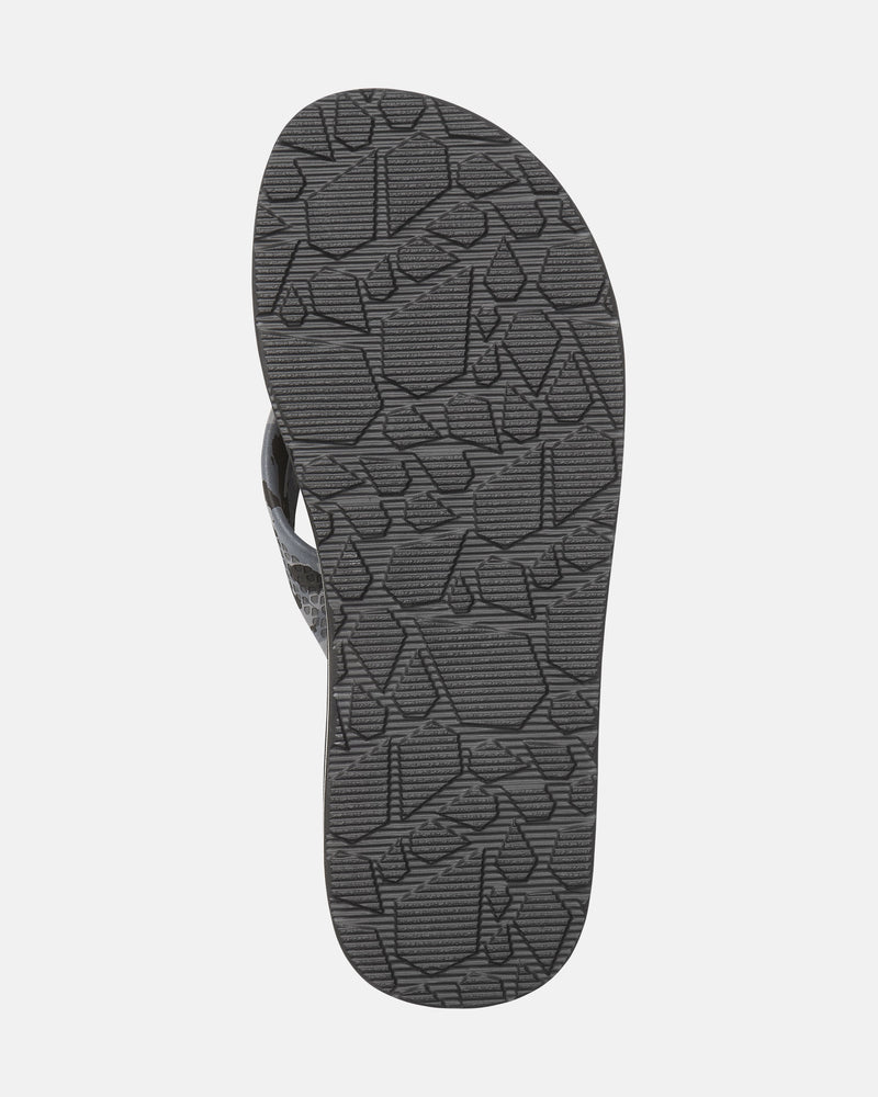 The image displays the sole of the Volcom Men's Daycation 2 sandal, highlighting its gray rubber outsole with a textured geometric pattern designed for superior grip.