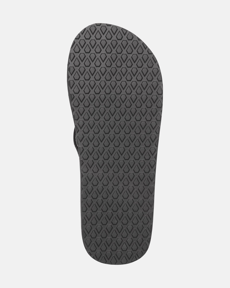 The image shows the sole of the Men's Vol-Commuter Sandals by Volcom, featuring a black flip-flop design with a diamond-shaped textured grip pattern against a plain white background.