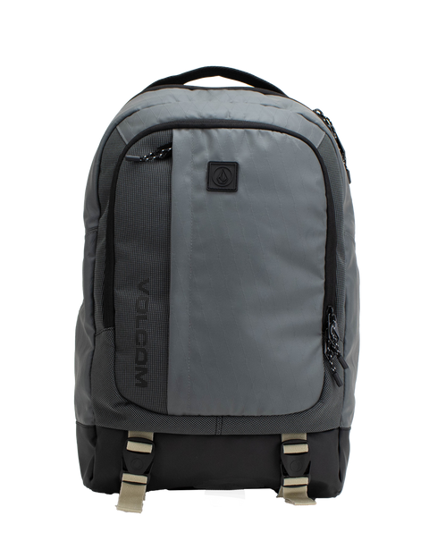 The Volcom Men's Venture Backpack features a gray design with a black bottom, front pocket, side zippers, and beige buckle straps. A small black logo patch accents the upper front. With a 22L capacity and padded laptop sleeve, this backpack offers a simple and functional style ideal for everyday use.