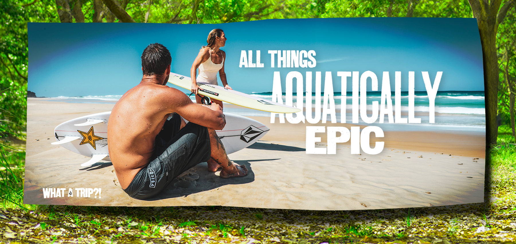 Two people with surfboards on a beach, text 'All Things Aquatically Epic' overlayed.