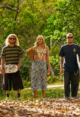 Three people standing outdoors with trees in the background