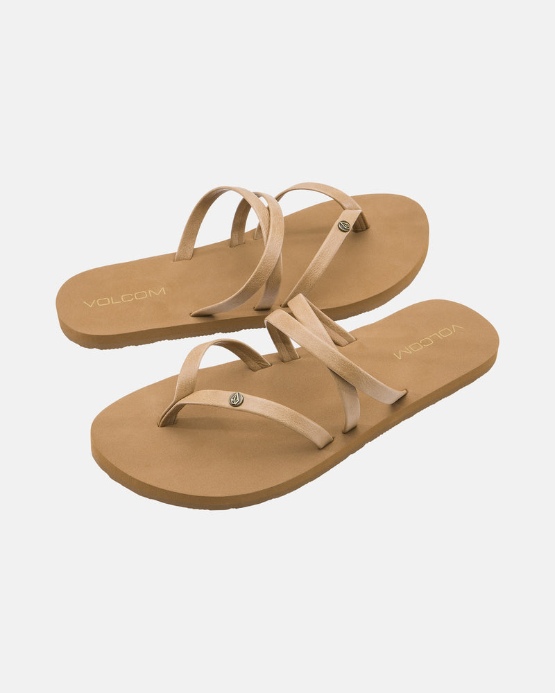 The Volcom Women's Easy Breezy II sandals feature a tan color, flat soles, multiple thin crisscrossing straps, and a comfortable EVA footbed, shown on a white background.