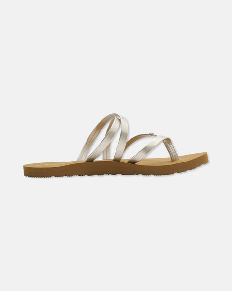 The Easy Breezy II features beige strappy sandals with a flat tan sole and metallic crisscross straps. An EVA footbed provides added comfort. Displayed on a white background.