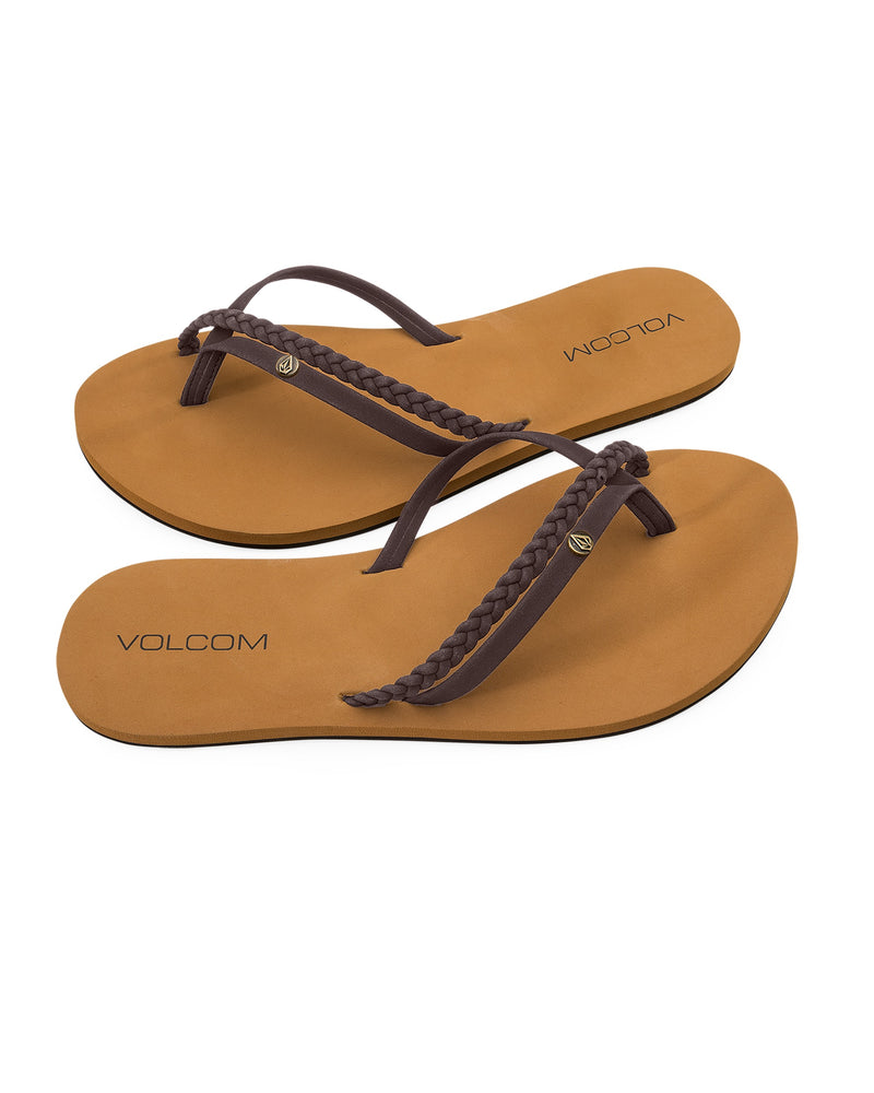 The Volcom Women's Thrills II tan flip-flops feature brown synthetic leather braided straps, VOLCOM branding on the footbed, and Recliner Comfort Foam for plush cushioning. Displayed on a white background.