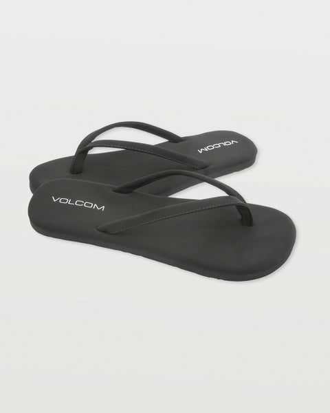 A pair of Women's Vibes flip-flops by Volcom in black with white branding on the footbeds, shown on a white background.