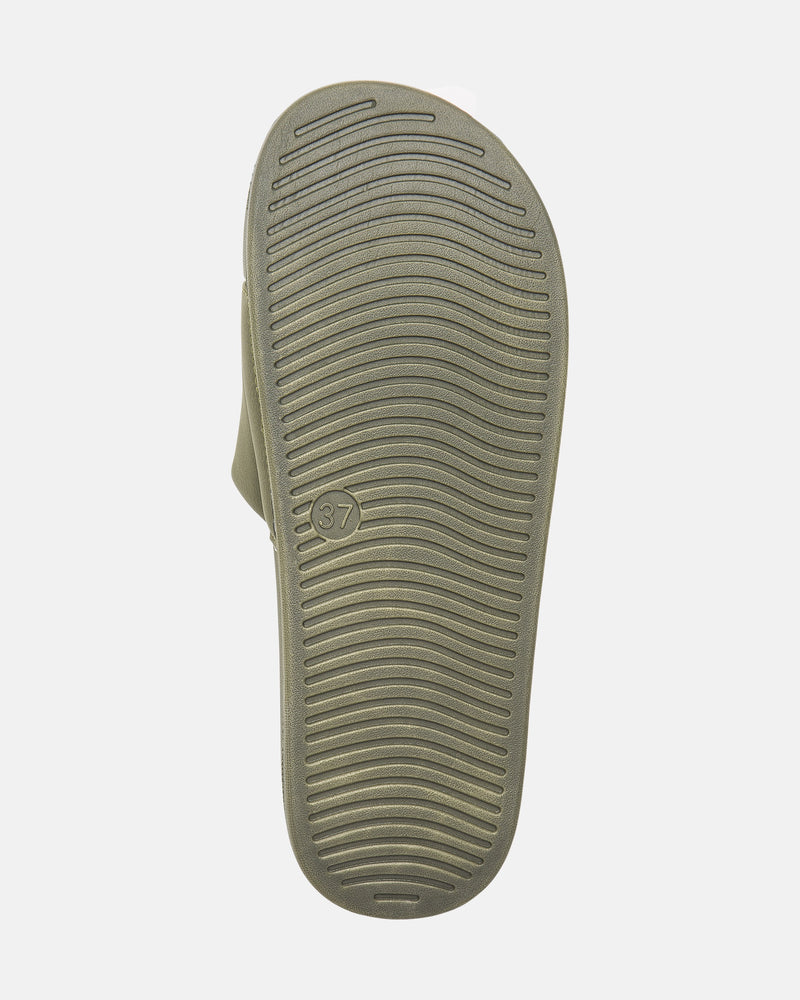 The image shows the sole of Volcom Women's Volcation Slides, featuring curved horizontal grooves for grip and a small circle with the number 37 near the arch, combining signature Volcom style with everyday comfort.