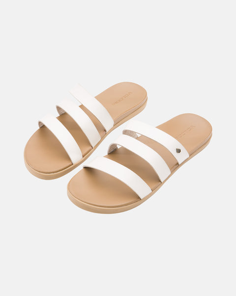 The Volcom Women's Sunseeker Sandals are beige flats featuring three white straps across the top, shown against a plain white background.