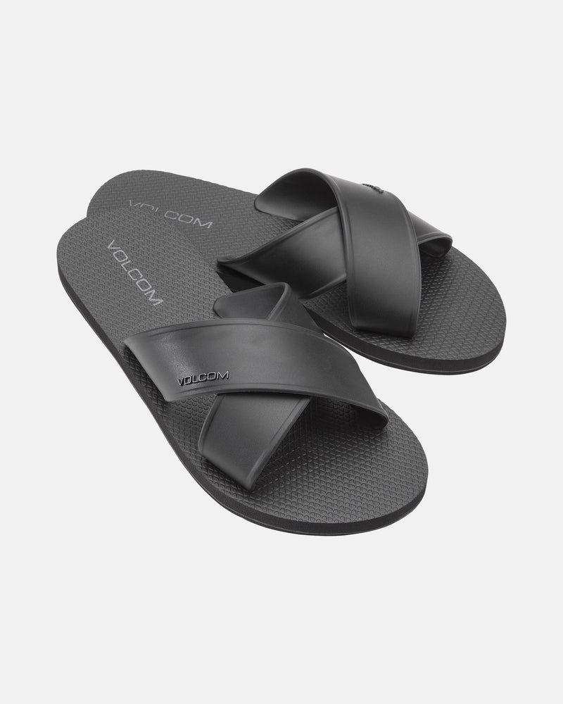 The Women's Volcomotion Strap Sandals by Volcom feature black crisscross straps and textured soles, with the brand name visible on the straps and footbeds, displayed against a plain white background.