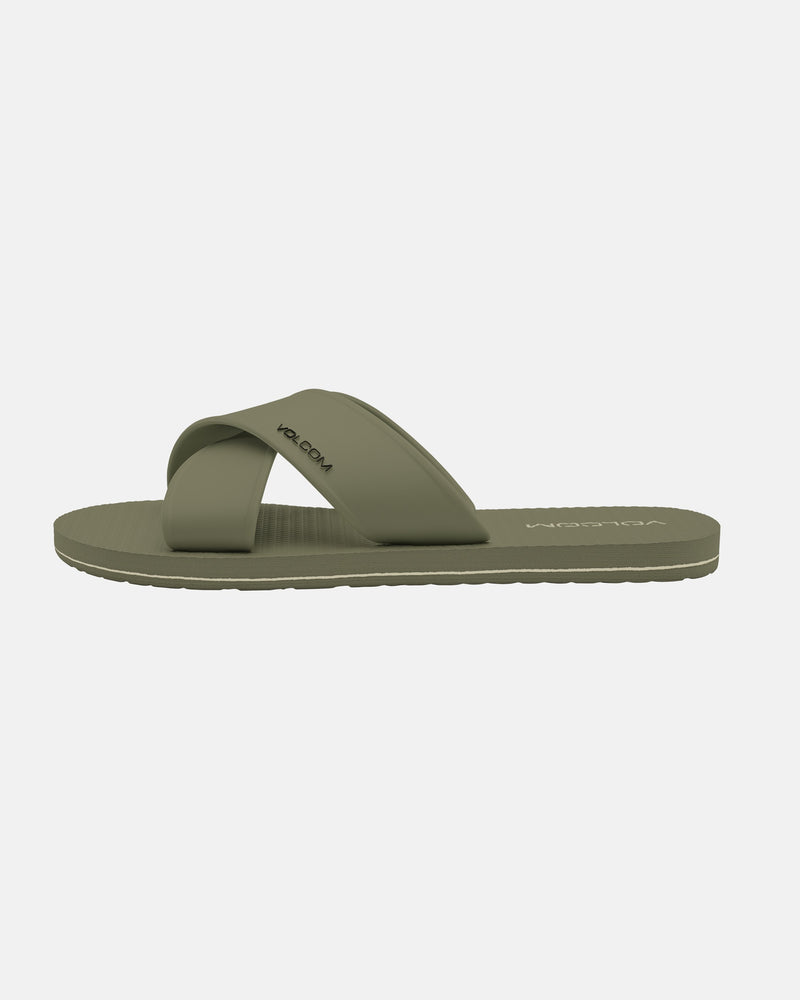 A single Women's Volcomotion Strap Sandal by Volcom in olive green, featuring crisscross straps and a textured sole, is displayed against a plain white background.