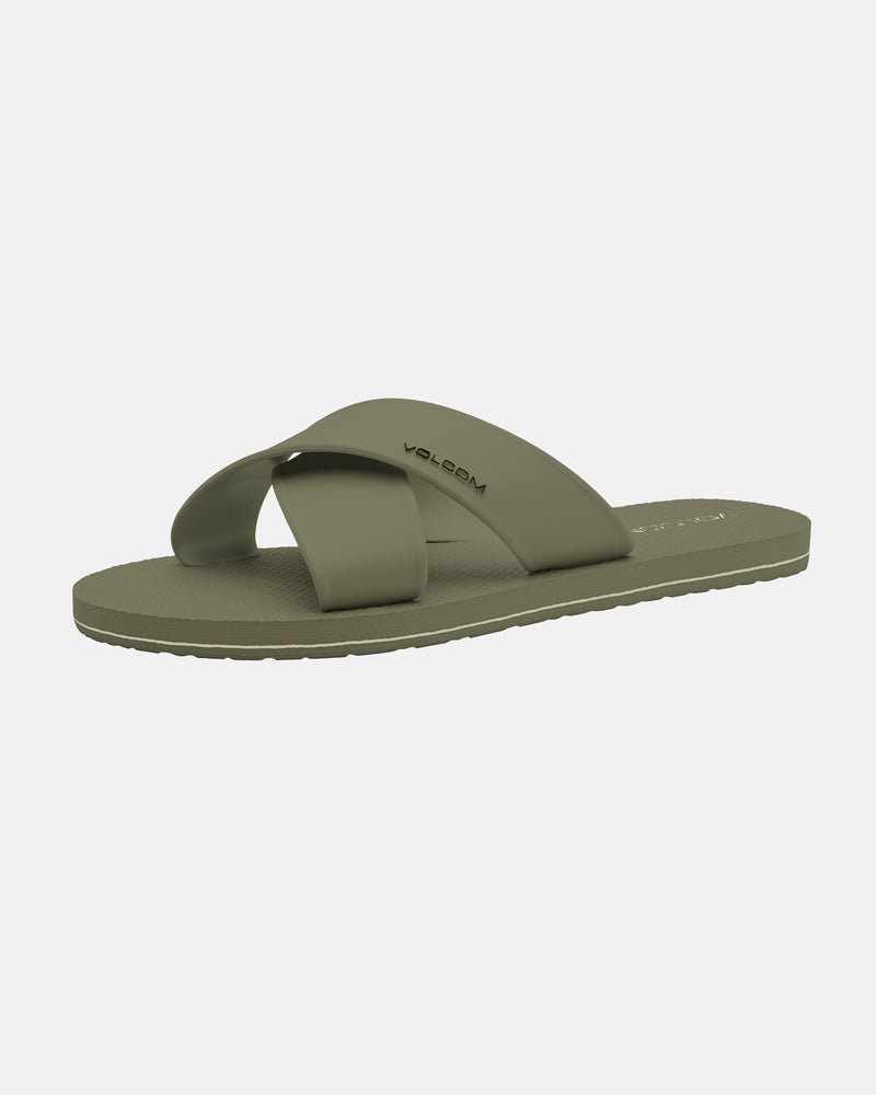 Women's Volcomotion Strap Sandals by Volcom in olive green, featuring two wide, crisscrossing straps with the brand name on the upper. Flat sole with a textured grip. Displayed against a plain white background.