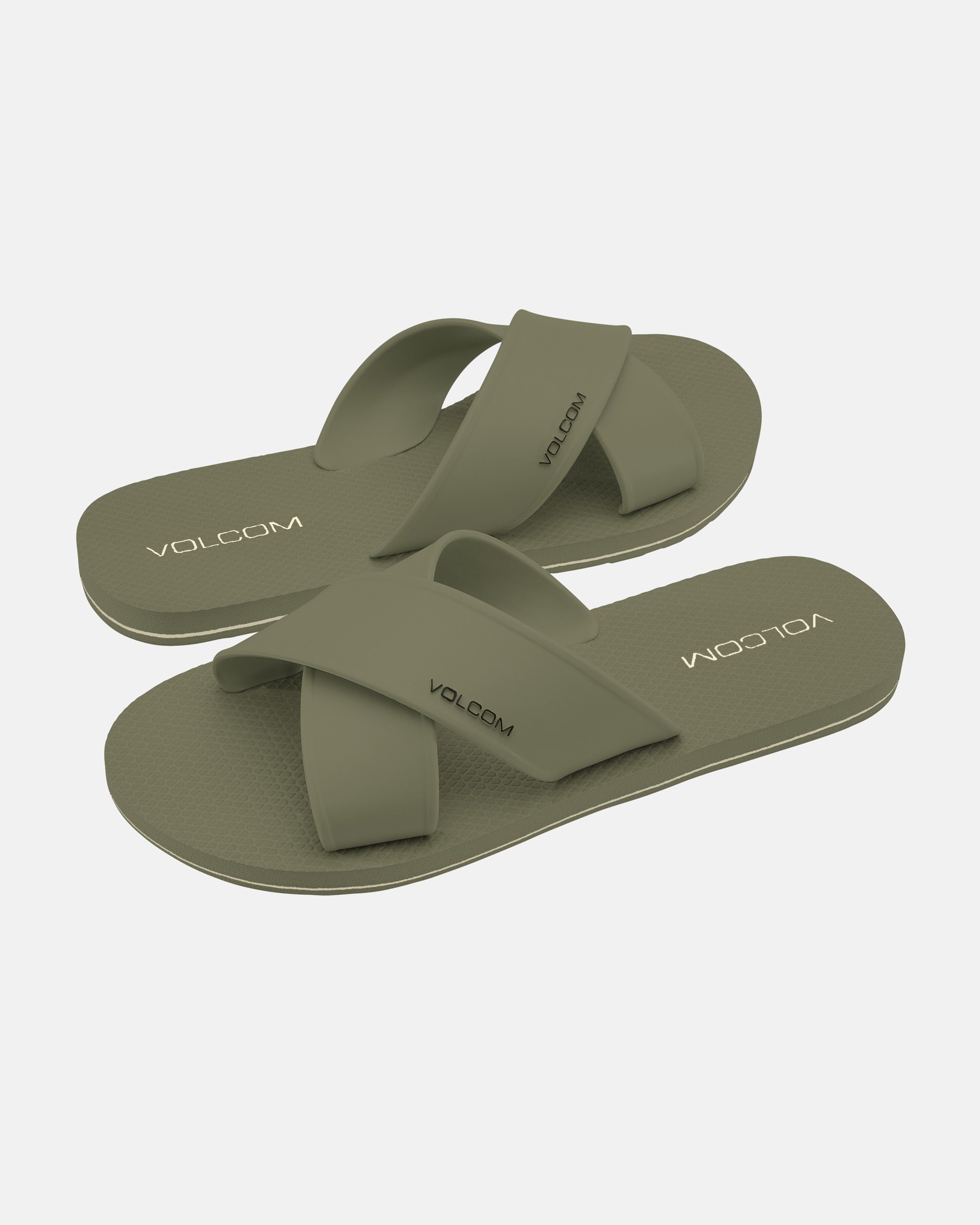 A pair of women's Volcom Volcomotion Strap Sandals in olive green with wide criss-cross straps and textured soles, featuring the Volcom logo on the footbed and strap, displayed on a white background.